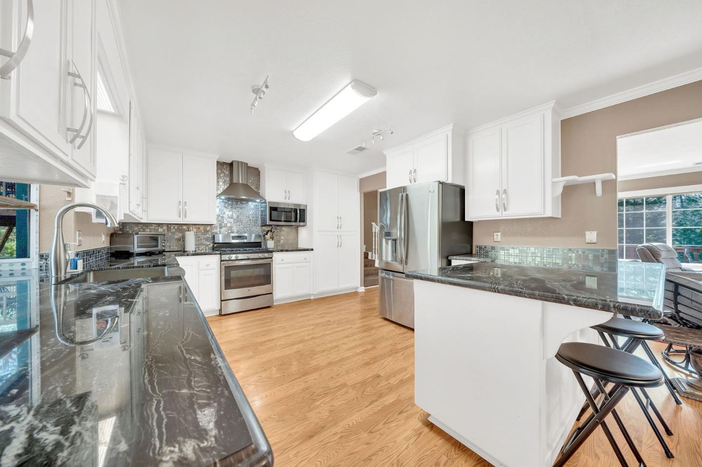 26161 Sugar Pine Drive Pioneer, CA 95666 - Photo 16 of 57 a kitchen with stainless steel appliances granite countertop a stove top oven a sink a refrigerator and white cabinets