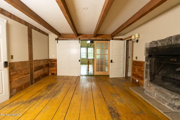 a view of hallway with wooden floor and furniture