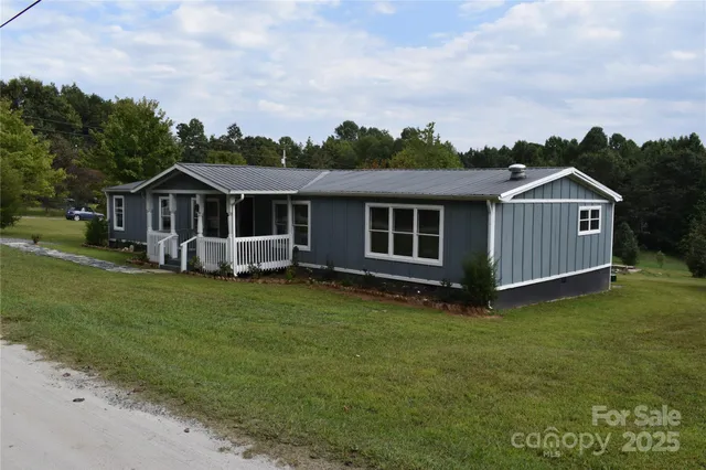 a view of a house with a big yard and large trees