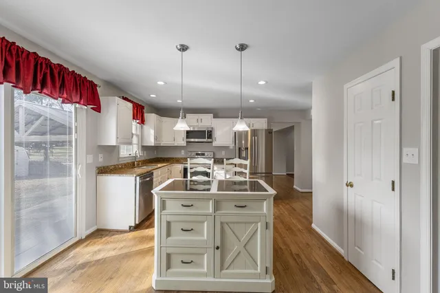 a kitchen with stainless steel appliances granite countertop a sink a stove and a refrigerator