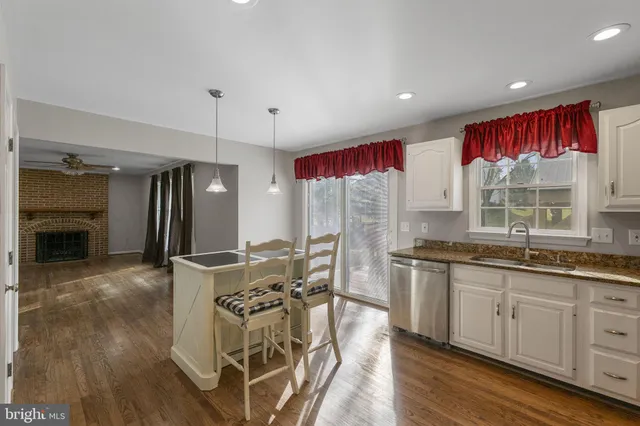 a kitchen with stainless steel appliances granite countertop a stove refrigerator sink and wooden floor