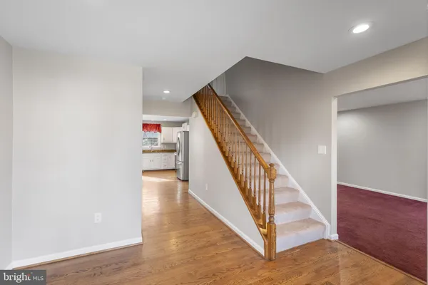 a view of a hallway with wooden floor and staircase