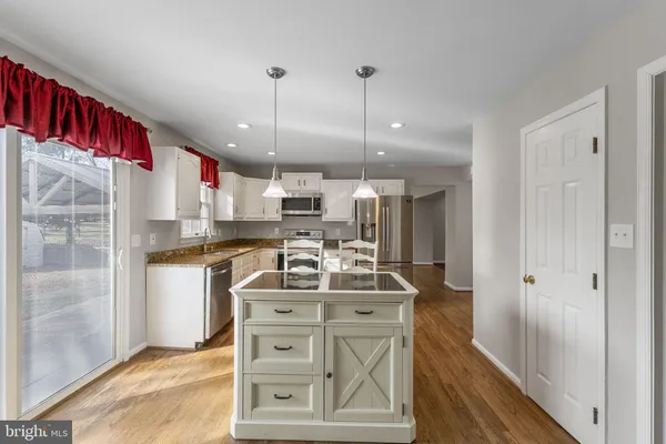 a kitchen with stainless steel appliances granite countertop a sink a stove and a refrigerator