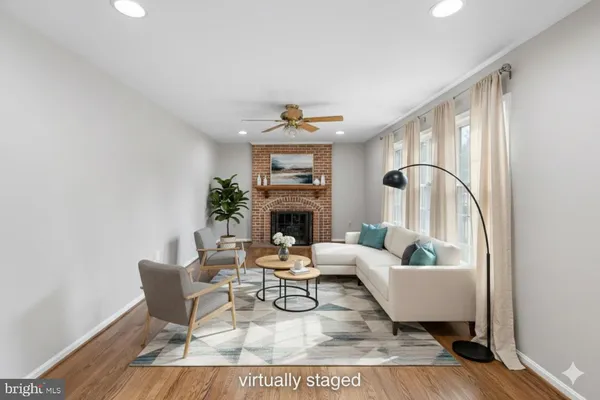 a living room with furniture a fireplace and a potted plant