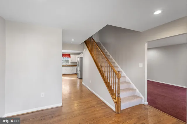 a view of a hallway with wooden floor and staircase