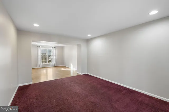 an empty room with floor to ceiling windows and ceiling fan