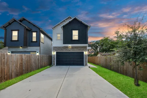 a front view of a house with a yard and garage