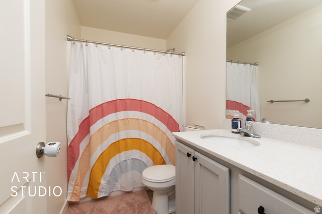 1713 South Windemere Road Santaquin, UT 84655 - Photo 19 of 40 Bathroom featuring a built-in vanity with a white countertop and undermount sink, a large wall-mounted mirror, and a toilet with an adjacent shower area