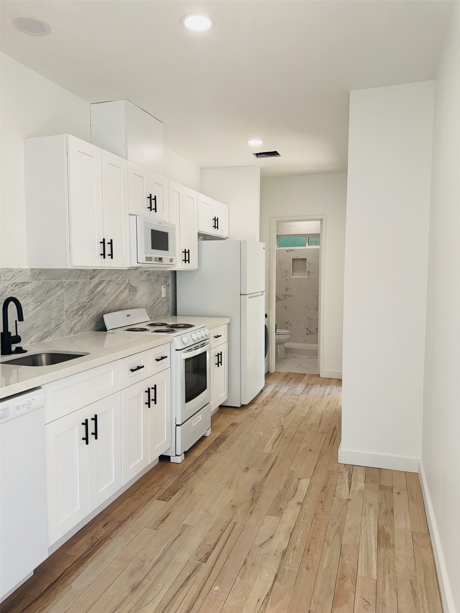 1235 West Gray Street, Unit 1 Houston, TX 77019 - Photo 5 of 10 a kitchen with granite countertop a sink and a stove top oven
