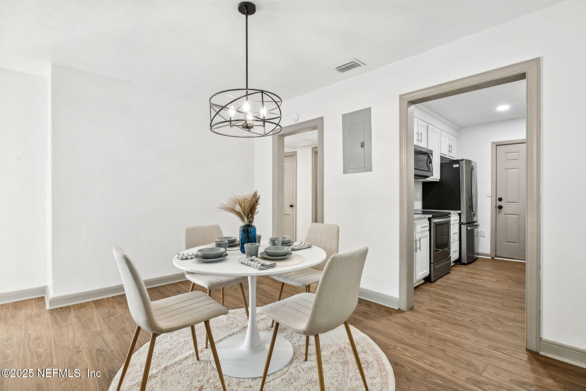 4615 Woolman Avenue Jacksonville, FL 32205 - Photo 17 of 34 a view of a dining room with furniture wooden floor and chandelier