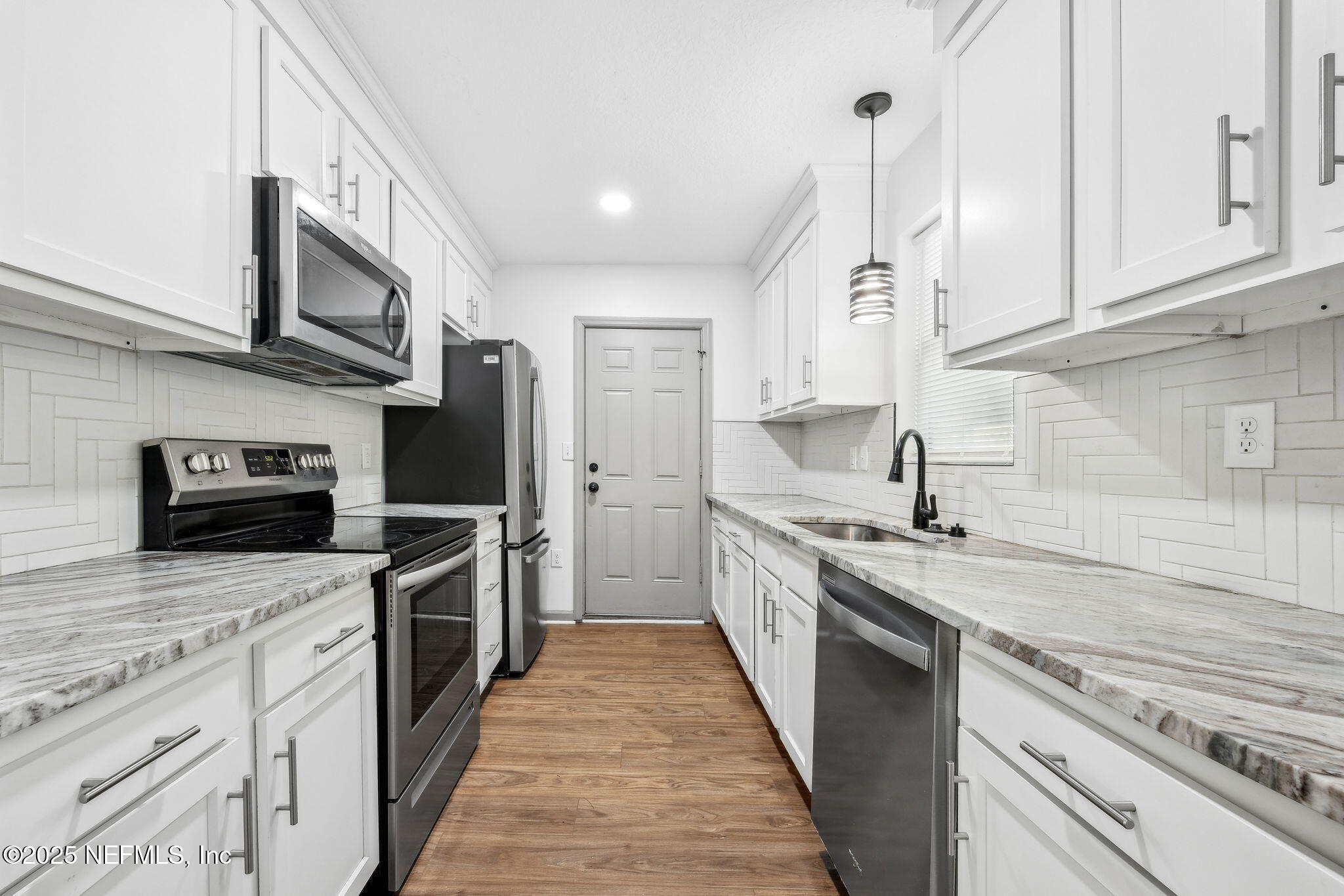 4615 Woolman Avenue Jacksonville, FL 32205 - Photo 18 of 34 a large kitchen with stainless steel appliances granite countertop a stove top oven a sink and dishwasher