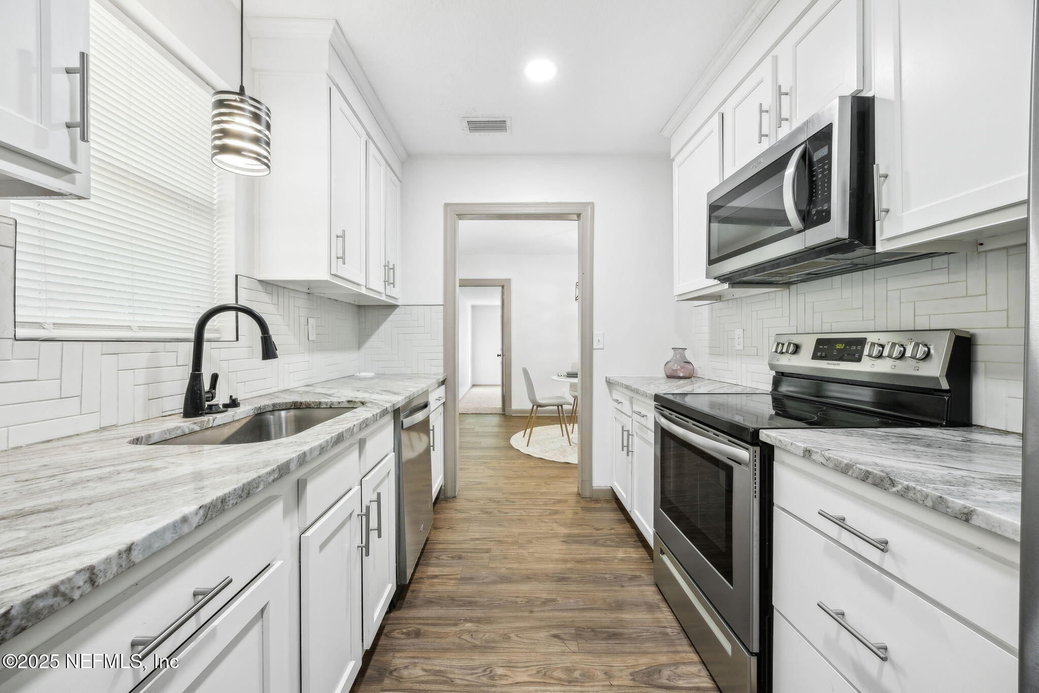 4615 Woolman Avenue Jacksonville, FL 32205 - Photo 19 of 34 a kitchen with stainless steel appliances granite countertop a sink and stove top oven
