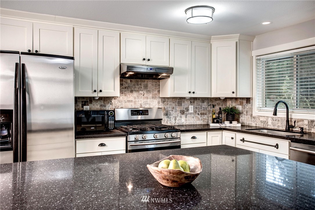 24326 Meridian Avenue South Bothell, WA 98021 - Photo 12 of 40 a kitchen with stainless steel appliances granite countertop a sink stove and refrigerator