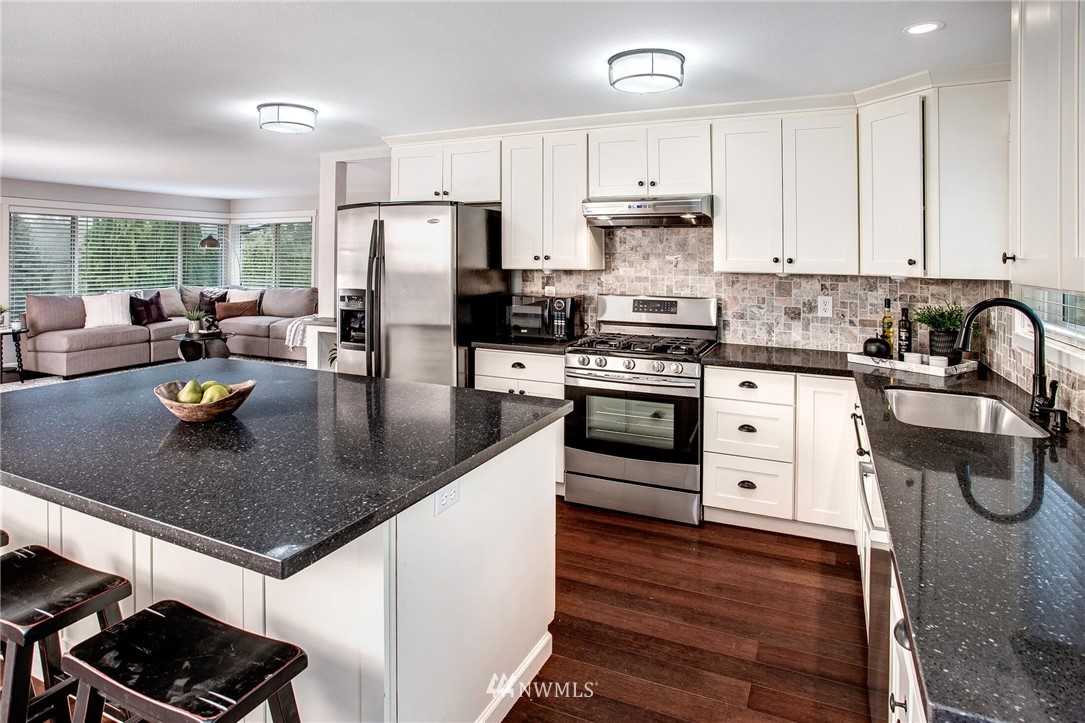 24326 Meridian Avenue South Bothell, WA 98021 - Photo 14 of 40 a kitchen with stainless steel appliances granite countertop a sink a stove and a refrigerator