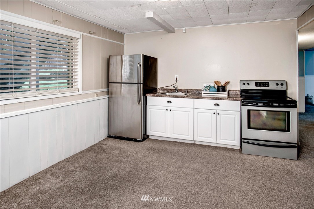 24326 Meridian Avenue South Bothell, WA 98021 - Photo 26 of 40 a kitchen with stainless steel appliances granite countertop a stove a refrigerator and a white cabinets