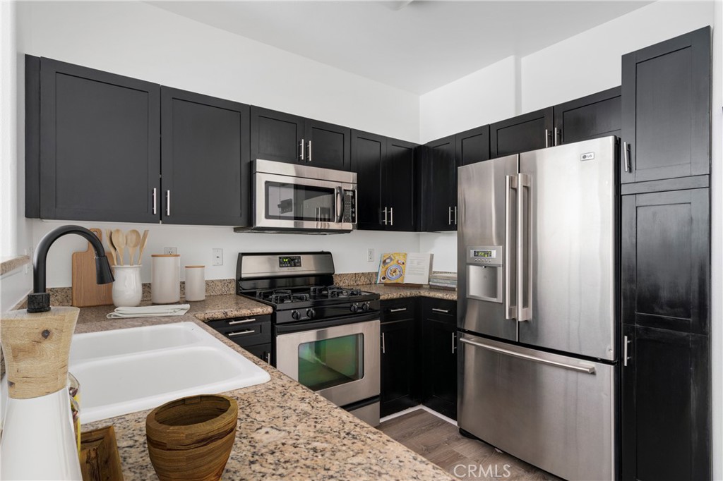 100 South Alameda Street, Unit 213 Los Angeles, CA 90012 - Photo 3 of 41 a kitchen with a refrigerator sink and stainless steel appliances