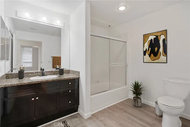 a bathroom with a granite countertop sink toilet and a mirror