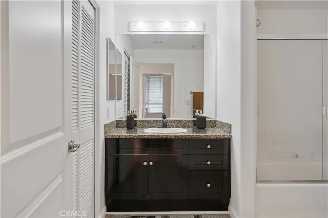 a bathroom with a granite countertop sink a large mirror and a
