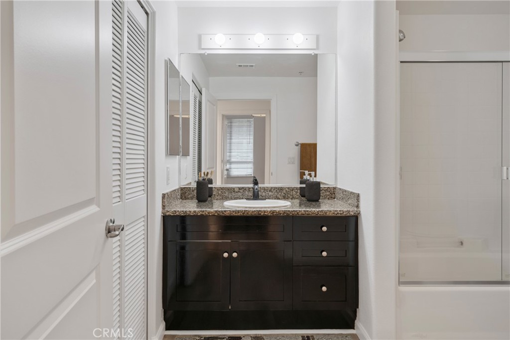 100 South Alameda Street, Unit 213 Los Angeles, CA 90012 - Photo 10 of 41 a bathroom with a granite countertop sink a large mirror and a
