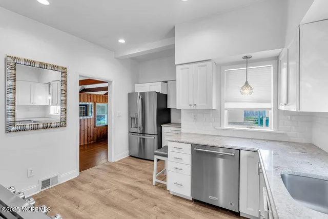 a kitchen with white cabinets and stainless steel appliances