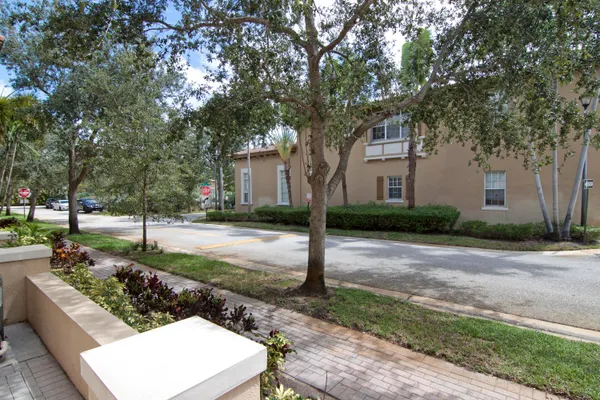 a front view of a house with a yard and tree s