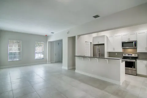 a kitchen with stainless steel appliances granite countertop a refrigerator and a stove top oven