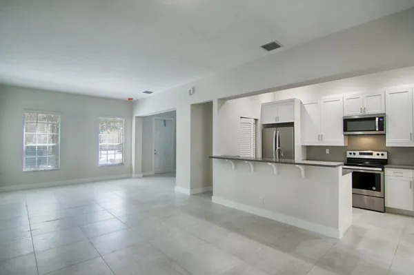 a kitchen with stainless steel appliances granite countertop a refrigerator and a stove top oven