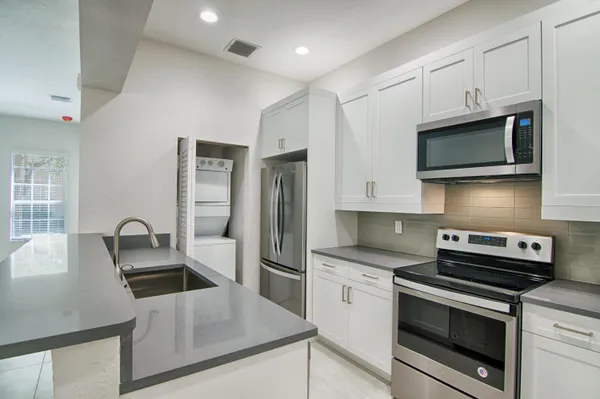 a kitchen with cabinets stainless steel appliances and a counter space
