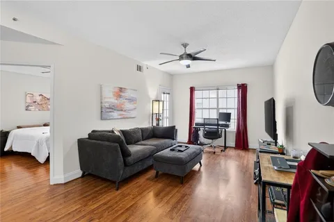 a living room with furniture a flat screen tv and a large window