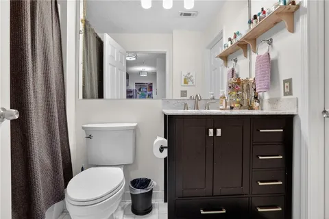 a bathroom with a sink a toilet a mirror and shower