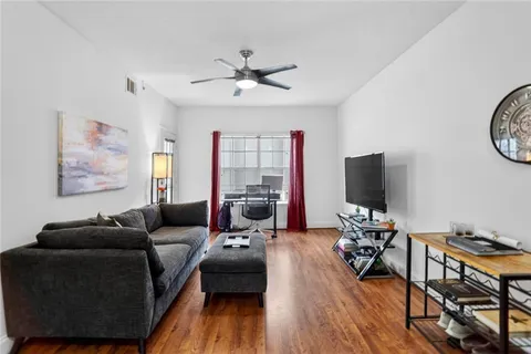 a living room with furniture a wooden floor and a flat screen tv
