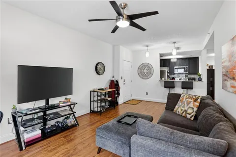 a living room with furniture and a flat screen tv with wooden floor