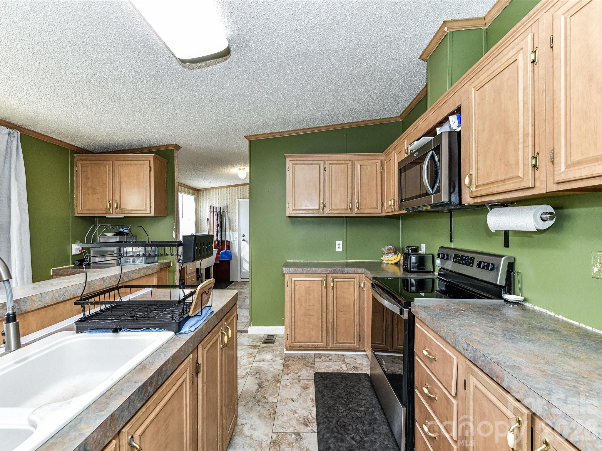 1565 Foxbrook Circle Lancaster, SC 29720 - Photo 13 of 28 a kitchen with a sink stove top oven and cabinets