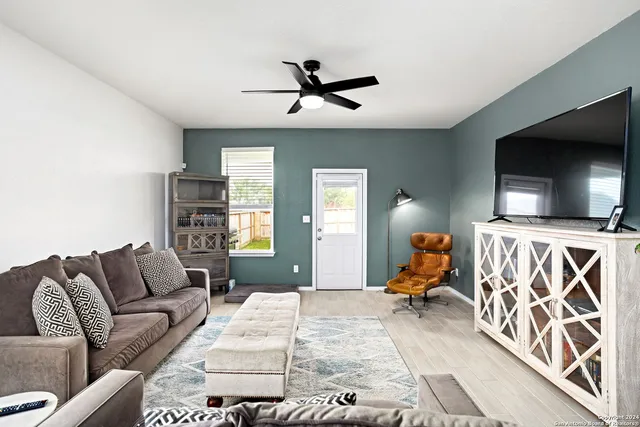 a living room with furniture flat screen tv and white walls