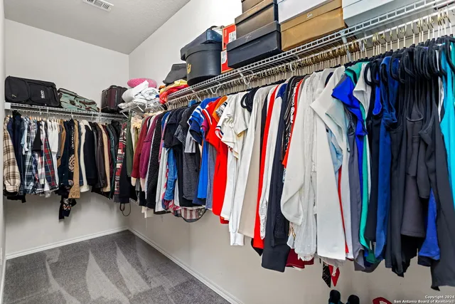 a view of walk in closet with clothes and shoes