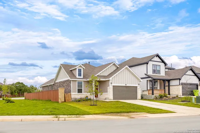 a view of a house next to a yard with big trees