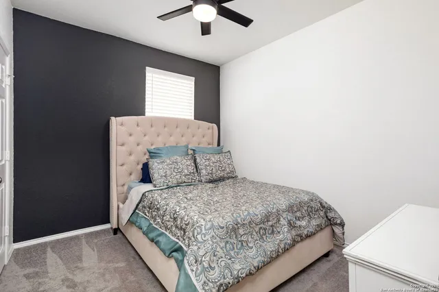 a bed sitting in a bedroom next to a window with a chandelier