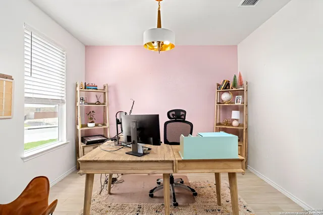 a view of a workspace with furniture and window