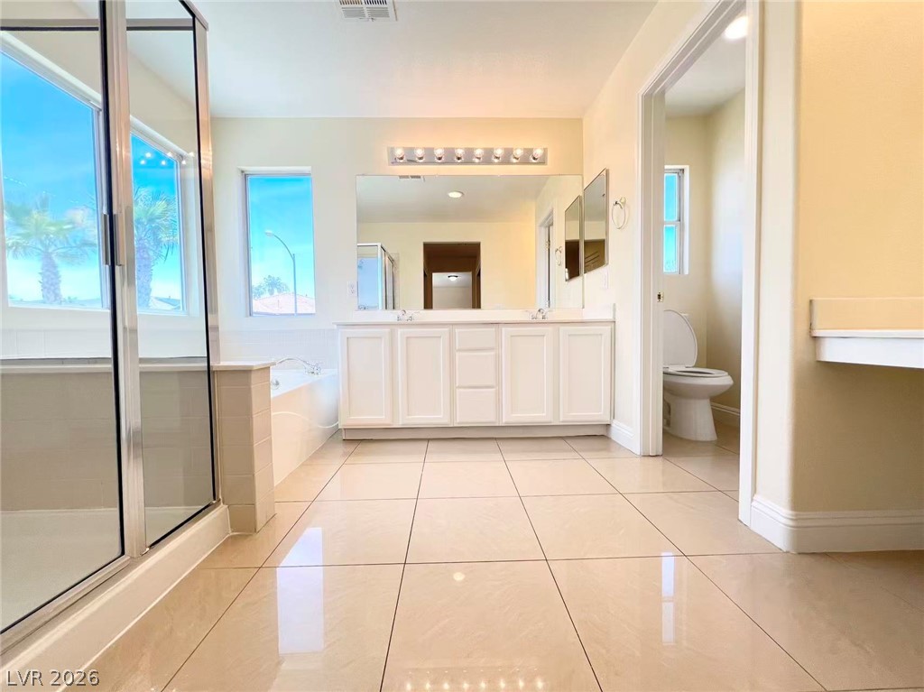 9891 Ridge Hill Avenue Las Vegas, NV 89147 - Photo 17 of 29 A primary bathroom featuring a spacious shower, soaking tub, and a dual vanity with expansive counter space.