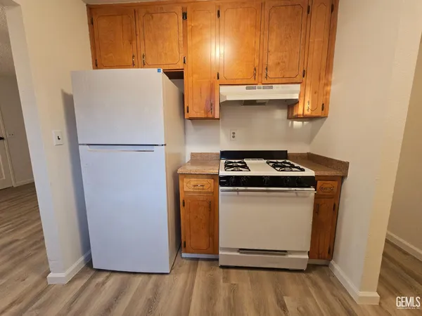 a white refrigerator freezer and a wooden floor