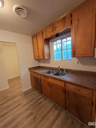 a kitchen with stainless steel appliances granite countertop a sink and a granite counter tops with wooden floors