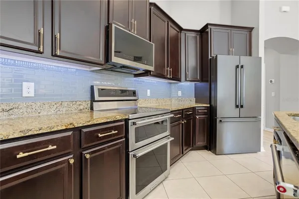 a kitchen with stainless steel appliances granite countertop a refrigerator and a sink