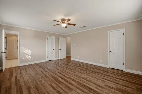 a view of empty room with wooden floor and ceiling fan
