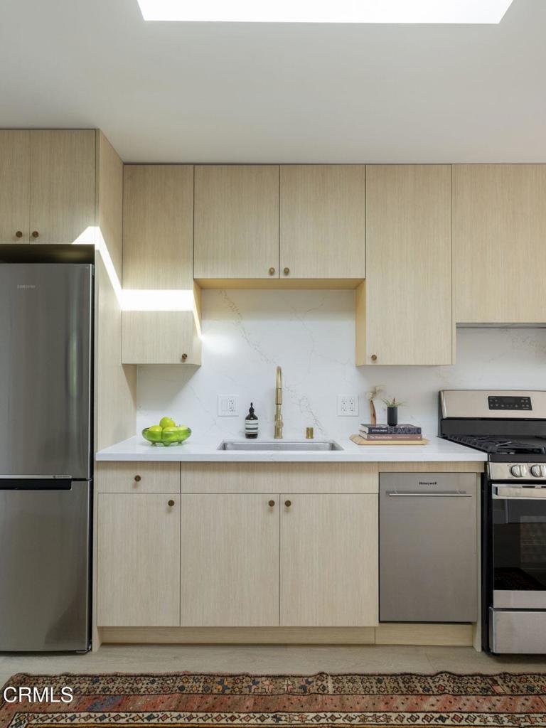 1158 Montecito Drive Los Angeles, CA 90031 - Photo 9 of 42 a kitchen with a sink a refrigerator and cabinets
