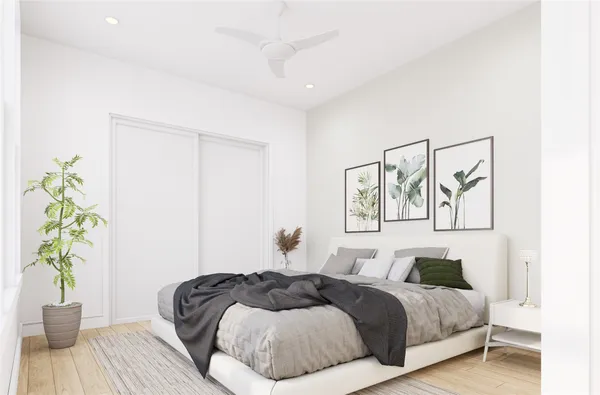 a bedroom with a bed and a potted plant
