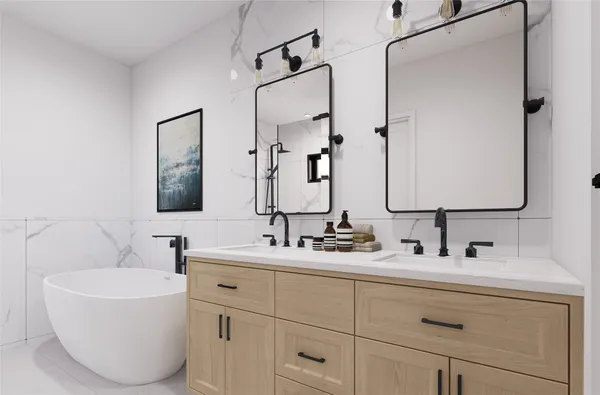 a bathroom with a double vanity sink mirror and bathtub