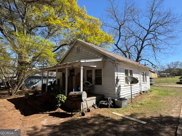 a view of a house with a cars park side of a road
