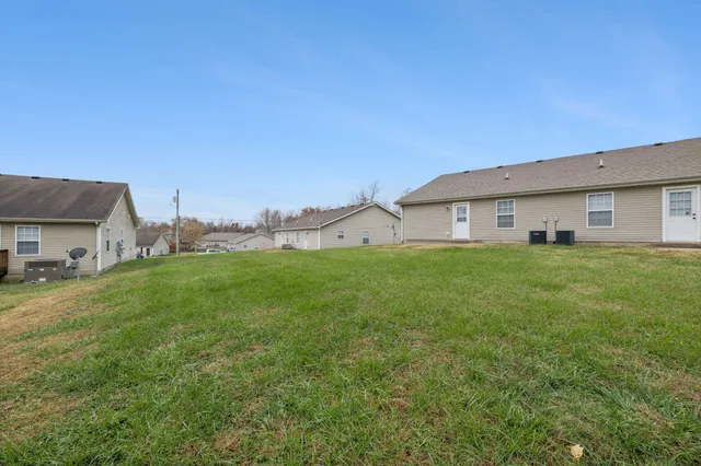 a big white house with a big yard and large trees