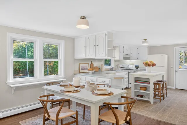 a kitchen with a table chairs and a window