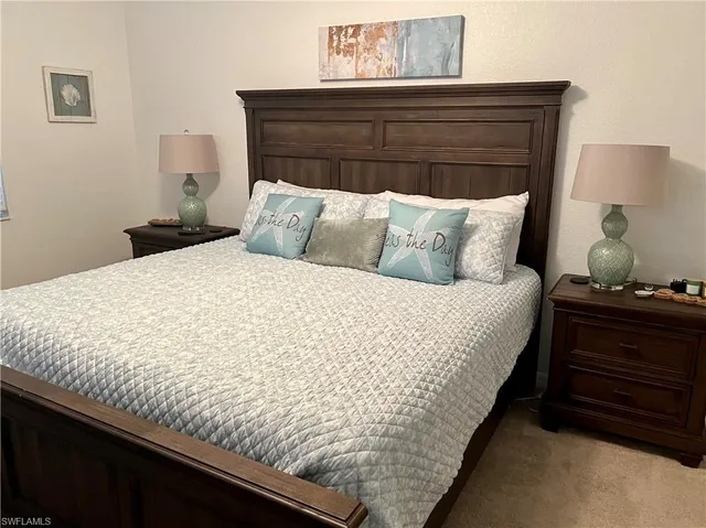 a bed sitting in a bedroom next to a lamp